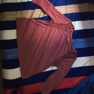 A burgundy long sleeve shirt with shoulder lace